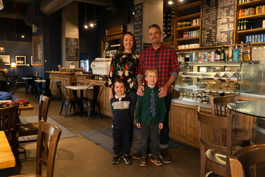 Andy Fennell, owner of Gravity Espresso & Wine Bar and his family standing inside the coffee bar
