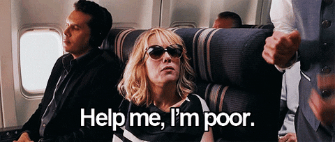 Animated gif of Kristen Wiig wearing sunglasses, slouched down in a first class airplane seat. Caption reads "Help me, I'm poor."